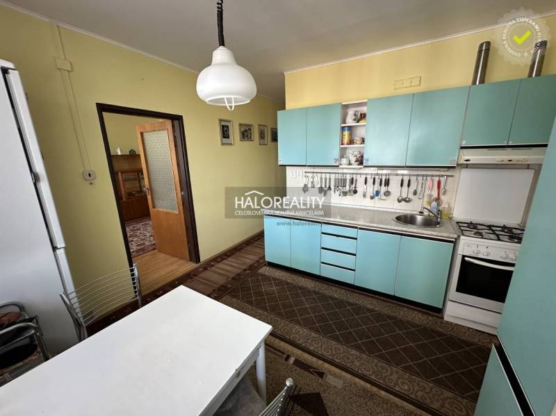A kitchen in a 3-room apartment with simple furniture and yellow walls.