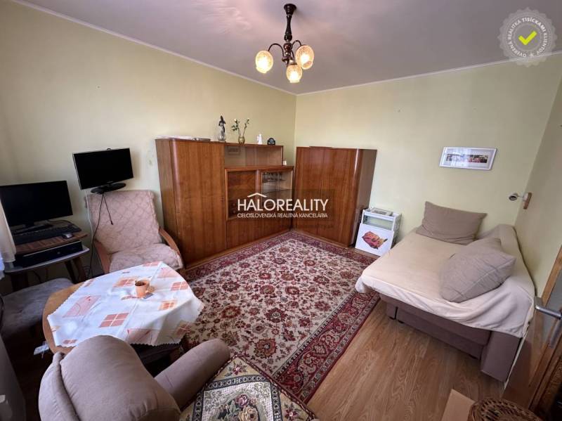 Living room in a 3-room apartment with armchairs, a carpet, and a wardrobe.