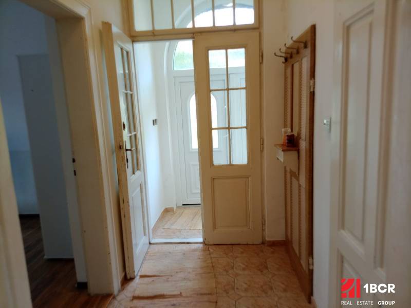 A hallway in a family house with white doors and tiles.