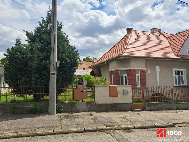 A family house on Nécseyho Street in Nitra with windows and a fence by the road.