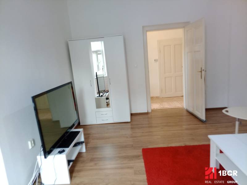 Living room with white furniture and wood-patterned flooring in a family house.