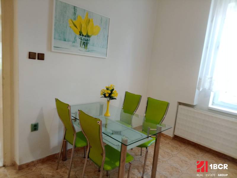 Glass dining table with green chairs in a family house.