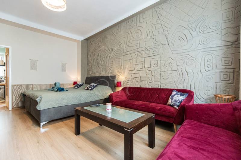 Living room in a two-room apartment with sofas and a decorative wall.