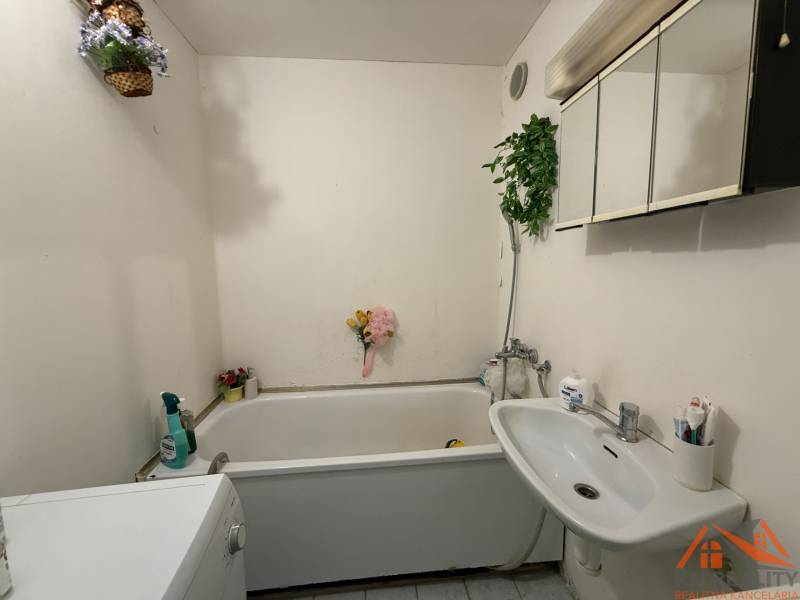 Bathroom in a 3-room apartment with a shower bath and a washing machine.