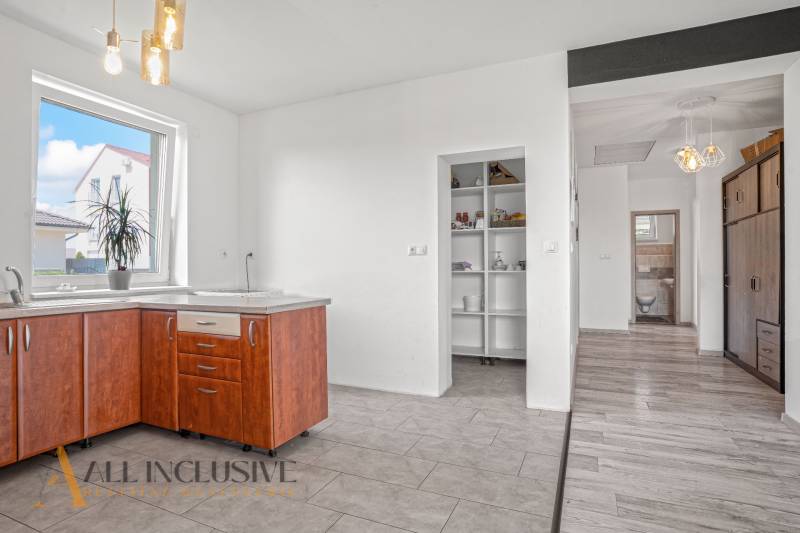 A kitchen in a family house with a wooden cabinet and built-in shelves.