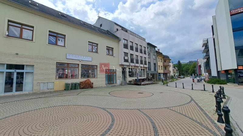 The building on Mostová Street in Ružomberok with a paved square and surrounding infrastructure.