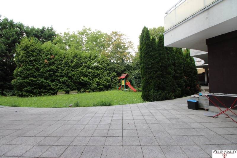 Courtyard with a lawn and a children's playground in the Commercial Spaces on Žatevná in Dúbravka.
