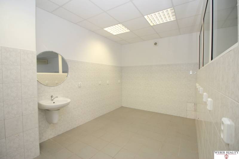 Interior with a sink, mirror, and backlit ceiling in commercial premises.