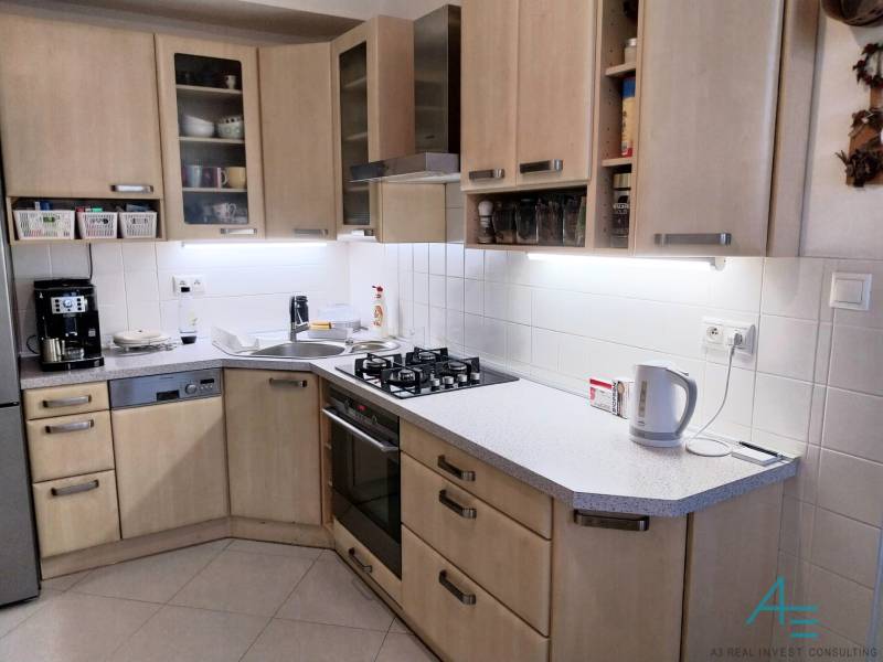 A kitchen in a 4-room apartment with wooden cabinets and modern appliances.