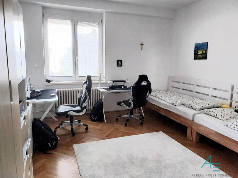 A room with two desks and a bed in a 4-room apartment.