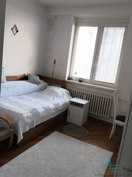 Bedroom with a bed, lamp, and window in a 4-room apartment.