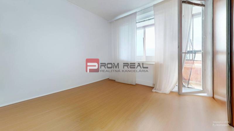 An empty room in a 3-room apartment with laminate flooring and a balcony.