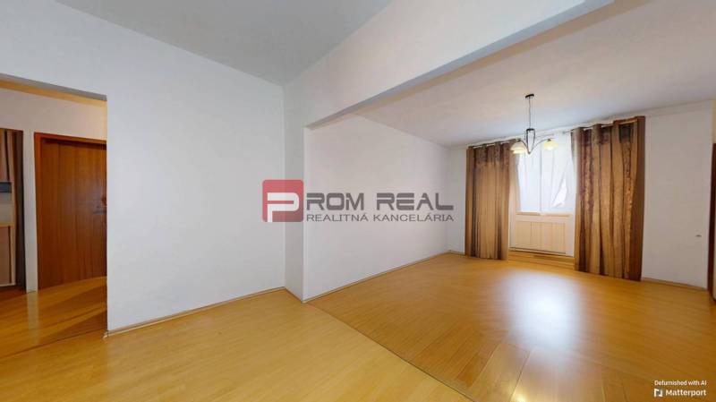 Interior of a 3-room apartment with laminate flooring and curtains on the window.