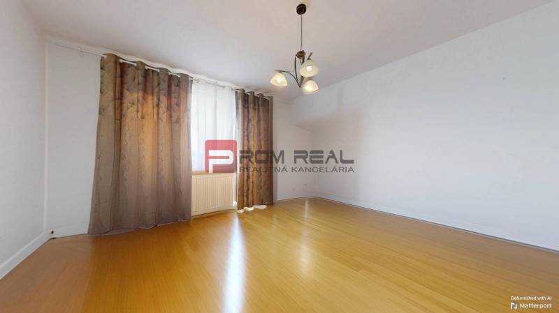 An empty room with wooden flooring and curtains, 3-room apartment.