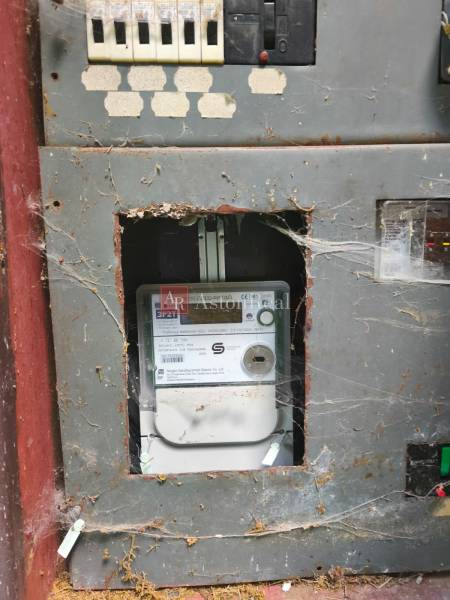 An old electrical panel with a spider web inside the cabin.