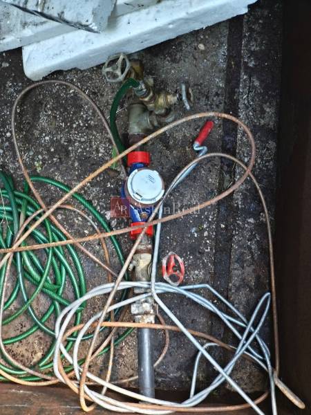 Water shut-off with a tangle of hoses in the cottage's boiler room.