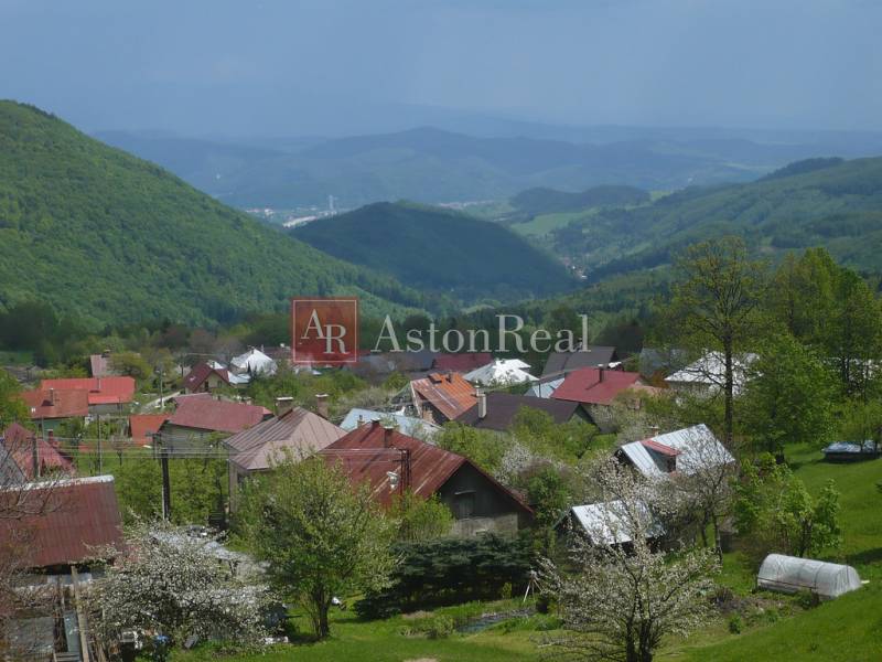 A view of the cottages in Kordíky near Banská Bystrica with picturesque hills in the background.