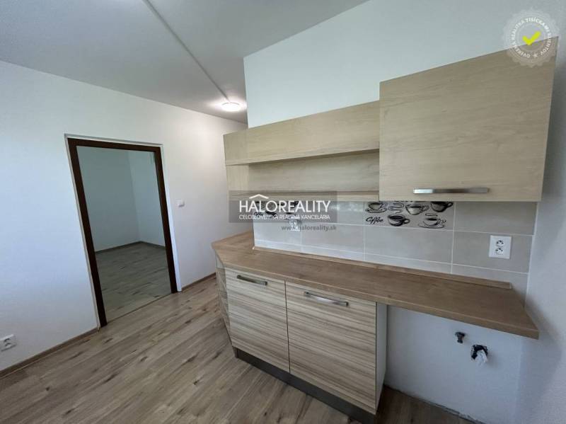 A kitchen in a 3-room apartment with wooden flooring and furniture.