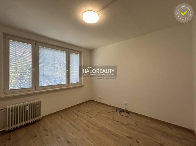 A room in a 3-room apartment with large windows and parquet flooring, unfurnished.