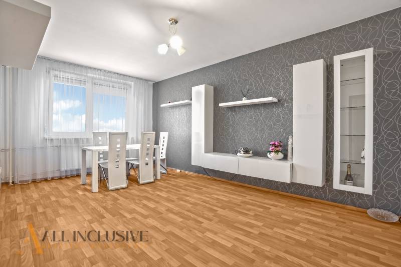 Dining area with a white table and chairs in a 2-room apartment.