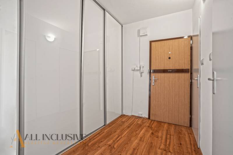 Entrance hallway in a 2-room apartment with wooden flooring and a built-in wardrobe.
