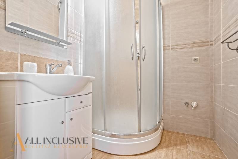 Bathroom with a sink and a shower in a 2-room apartment.