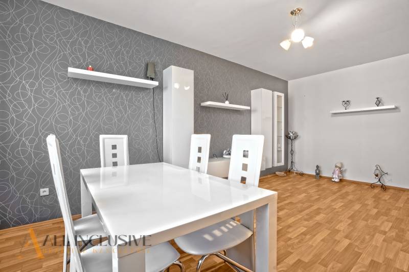 Dining room in a 2-room apartment with wooden flooring and white furniture.