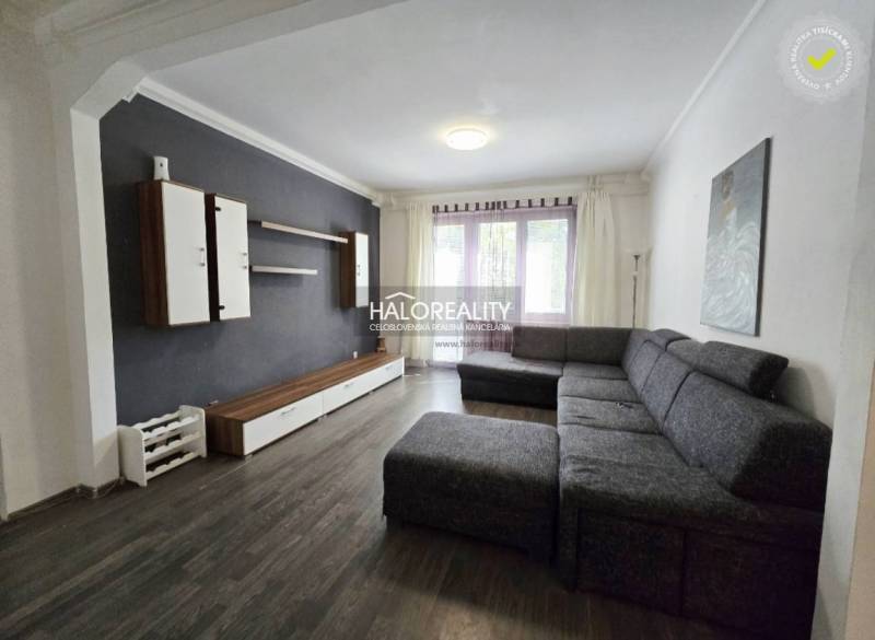 Living room of a three-room apartment with dark furniture and a comfortable sofa.