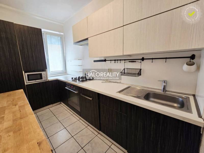 A kitchen in a 3-room apartment with a wooden countertop and built-in appliances.