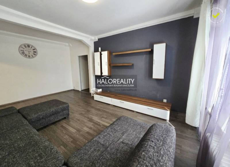 Living room in a 3-room apartment with a dark sofa and furniture.