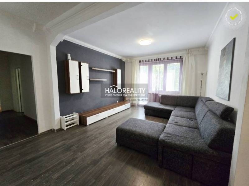 Living room in a 3-room apartment with a dark sofa and a furniture wall.