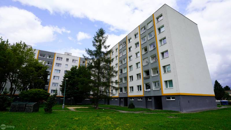 A housing estate with apartment buildings and greenery in Nova Dubnica, suitable for a 2-room apartment.