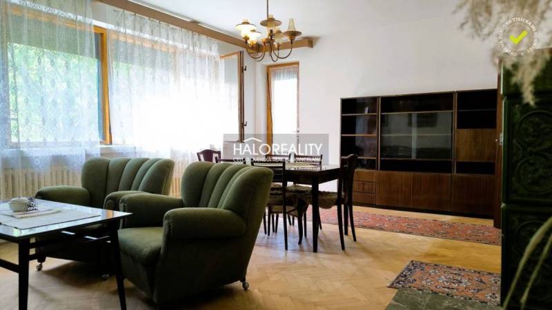 Living room in a family house with comfortable seating, a dining table, and a wooden cabinet.