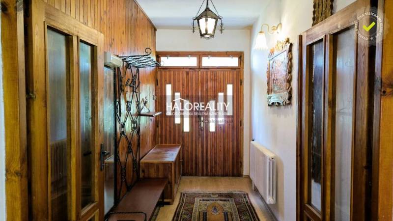A hallway in a family house with wooden paneling and a bench for sitting.