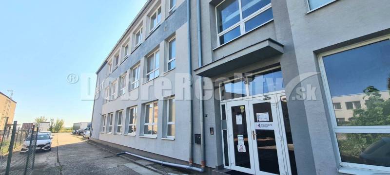 Office building on Priemyselná Street in Galanta with parking spaces.