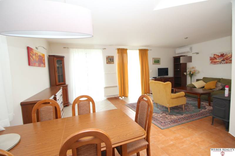 Living room in a family house with a dining table, sofa, and television.