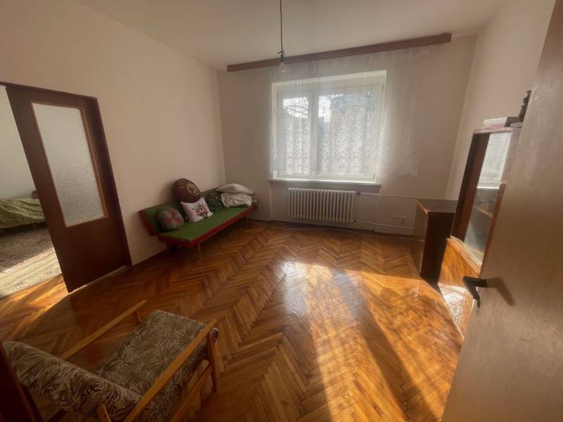 Wooden parquet in a bright room of a family house with a sofa and an armchair.