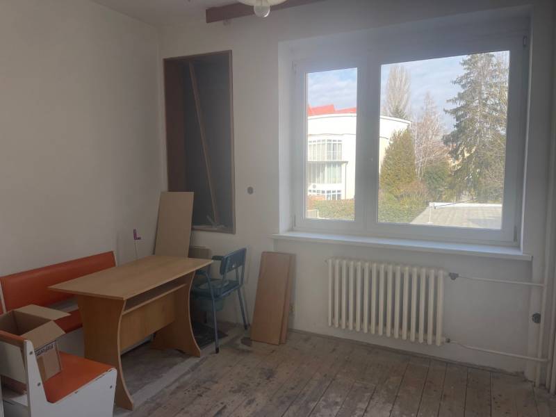 Interior of a family house with a window, table, and orange bench.