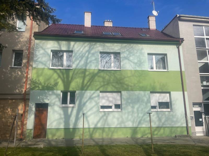 A family house on Kalinčiakova Street in Piešťany, green facade, shadow of a tree.