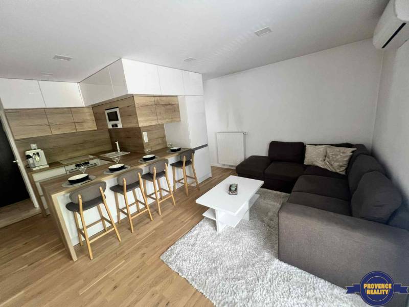 Living room in a 3-room apartment with a kitchen, bar counter, and corner sofa.
