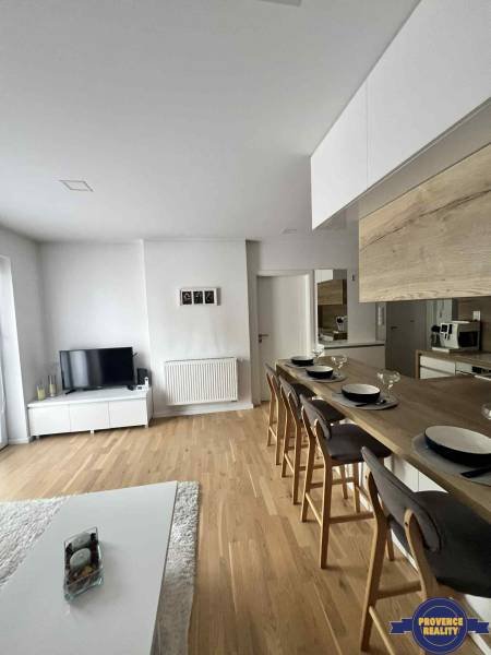 A bright living space with a television, kitchen, and dining counter in a 3-room apartment.