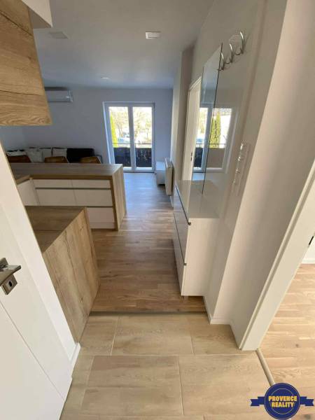 Bright interior of a 3-room apartment with wooden flooring and access to a terrace.