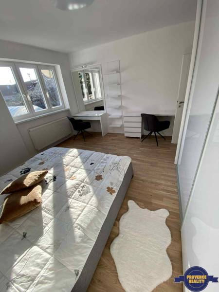 A bedroom in a 3-room apartment with light furniture, a bed, and a workspace.