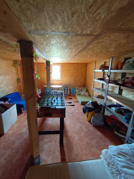 A room with wooden walls, a foosball table, shelves, and a window. Property - living.