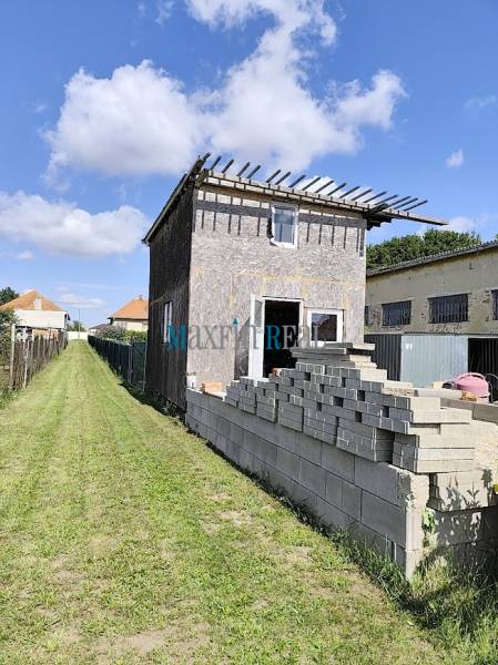 A building in Jelšovce with an unfinished exterior, intended for land - housing.
