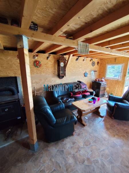 Interior with leather furniture, wooden ceiling, and fireplace, suitable for residential properties.