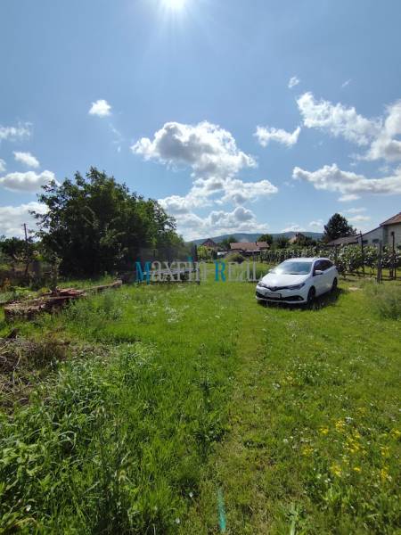 Green plot with a car in Jelšovce, suitable for living.