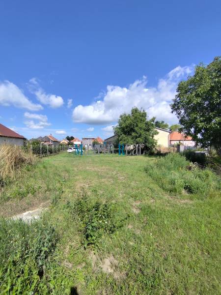 Plots - housing in Jelšovce with a view of the surrounding houses and blue sky.