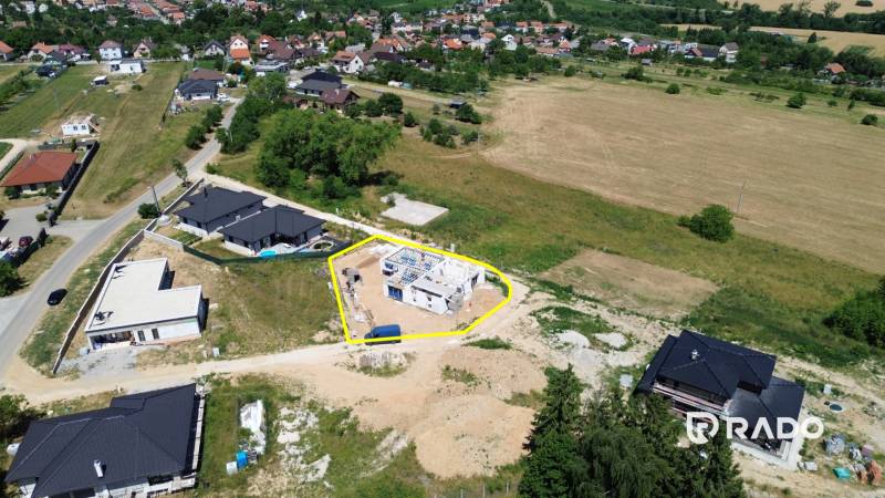 Construction site of a family house in Trenčianske Jastrabie surrounded by nature and neighboring houses.