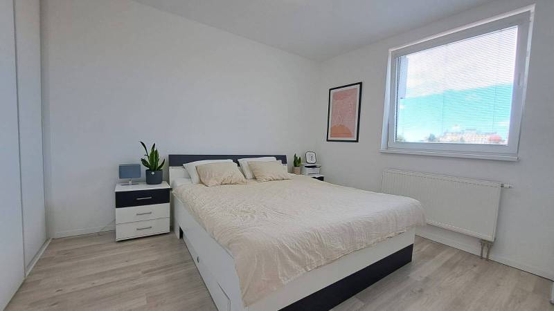 A bright bedroom with furnishings and a bed in a 2-room apartment, minimalist design.